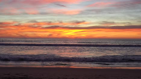 olas del océano en la playa con espectacular puesta de sol en el cielo