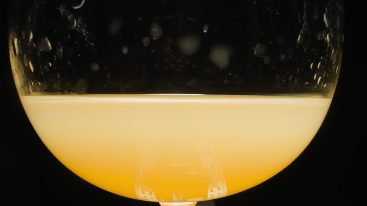 Succo d'arancia dolce con alcol versato in un bicchiere trasparente