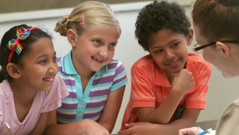 Teacher-and-pupils-working-at-desk-together