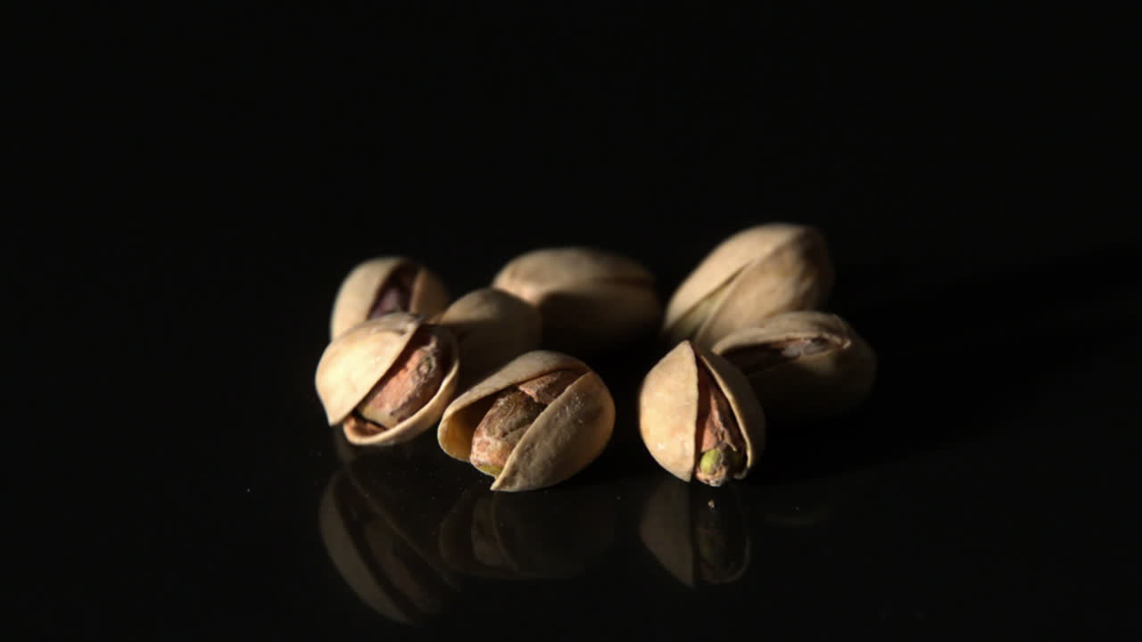 Pistacchi che cadono su una superficie nera
