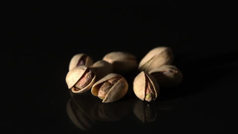 pistachio nuts falling on black surface