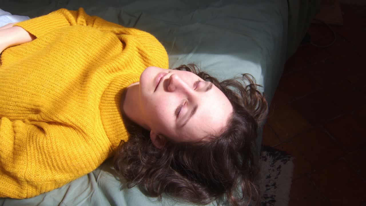 A Woman Lies on the Bed, Bathed in the Soft Glow of the Morning Sun - Close Up