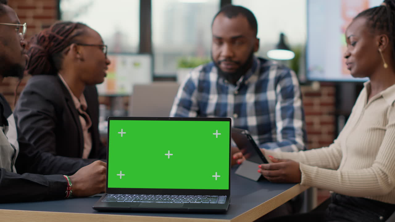 Businesspeople attending briefing meeting with greenscreen on laptop