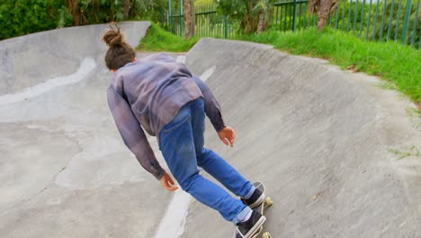 Vista-Frontal-De-Un-Joven-Caucásico-Practicando-Skate-En-Rampa-En-El-Parque-De-Skate-4k