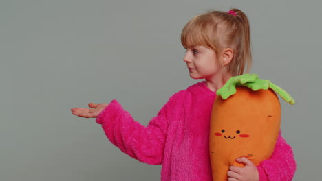 una niña con una zanahoria de peluche