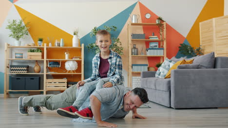 father and son playing in living room
