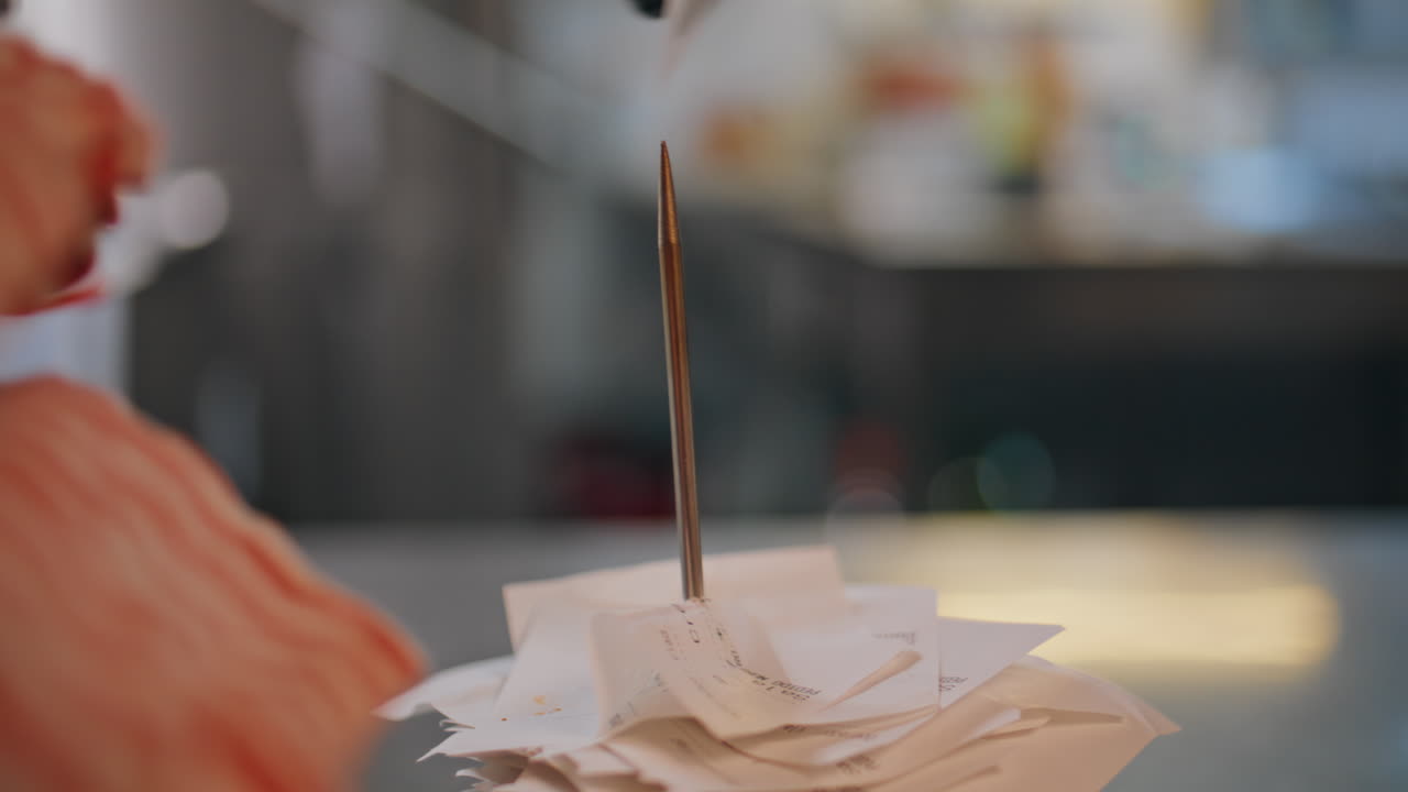 Closeup restaurant orders skewered on metal spike in catering establishment