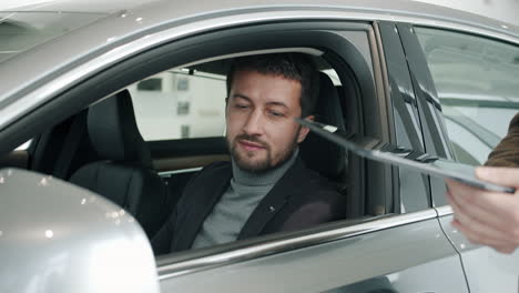 man discussing car purchase in showroom