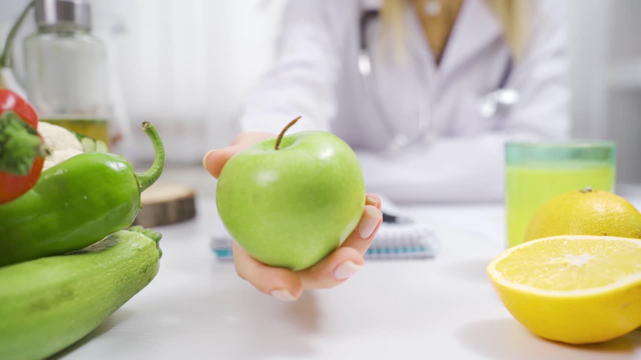 mujer con nutricionista positivo que muestra manzana verde.