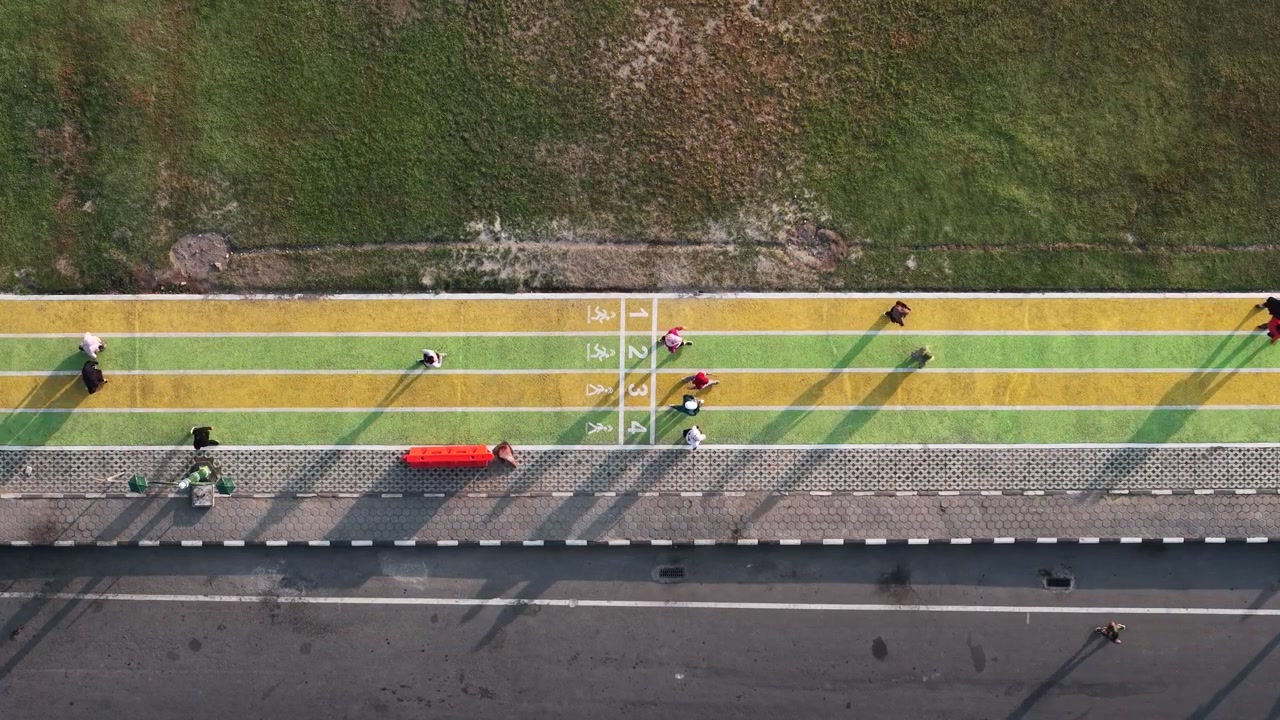 Nedoverrettet 4K droneopptak viser løpere som bruker joggeløypen på Paseban Field, Bantul, Indonesia