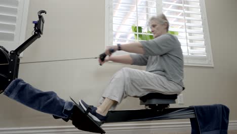 senior woman exercising on a rowing machine at home