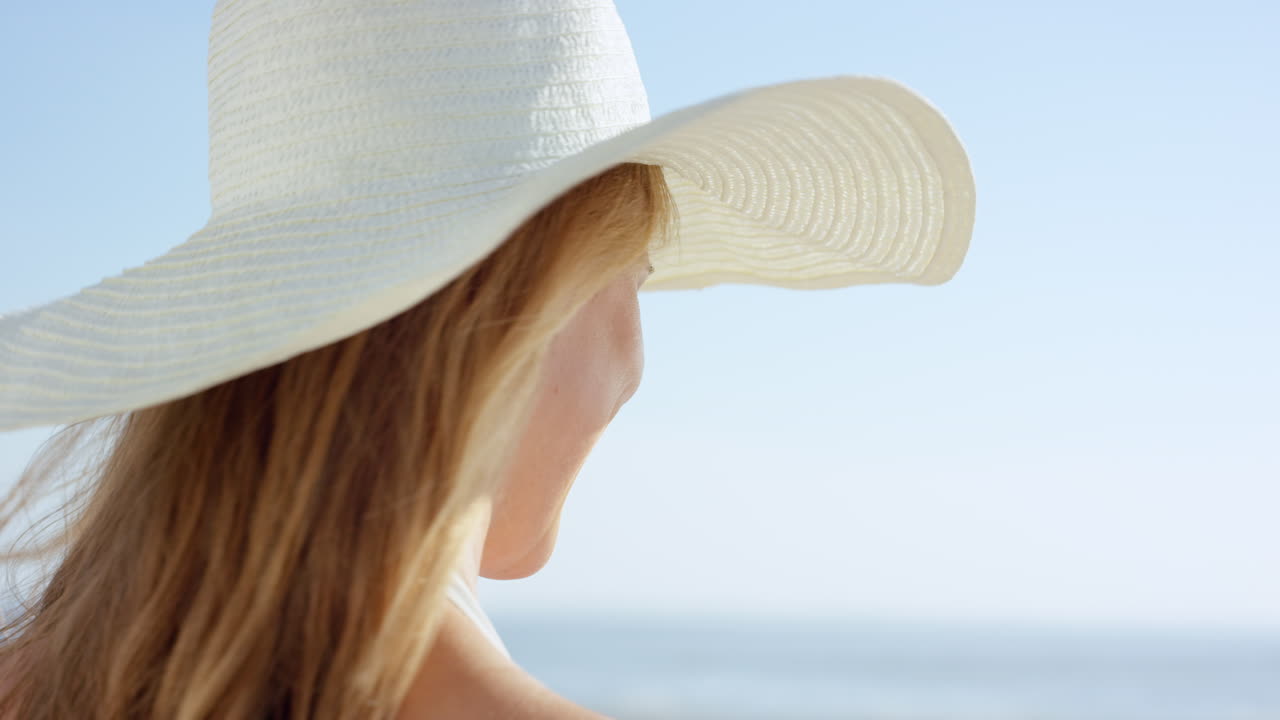 아름다운 여성이 해변을  ⁇ 고 카메라를 향해 미소 짓는 스테디캠 슬로우 모션  ⁇ 을 가 ⁇ 게 찍습니다.