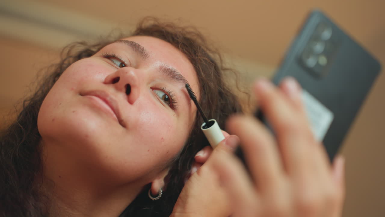 Selfassured lady makes final beauty adjustments. Calm woman finetunes eyebrows before her significant appointment. Poised lady in hotel finalizes her appearance to impress at meeting