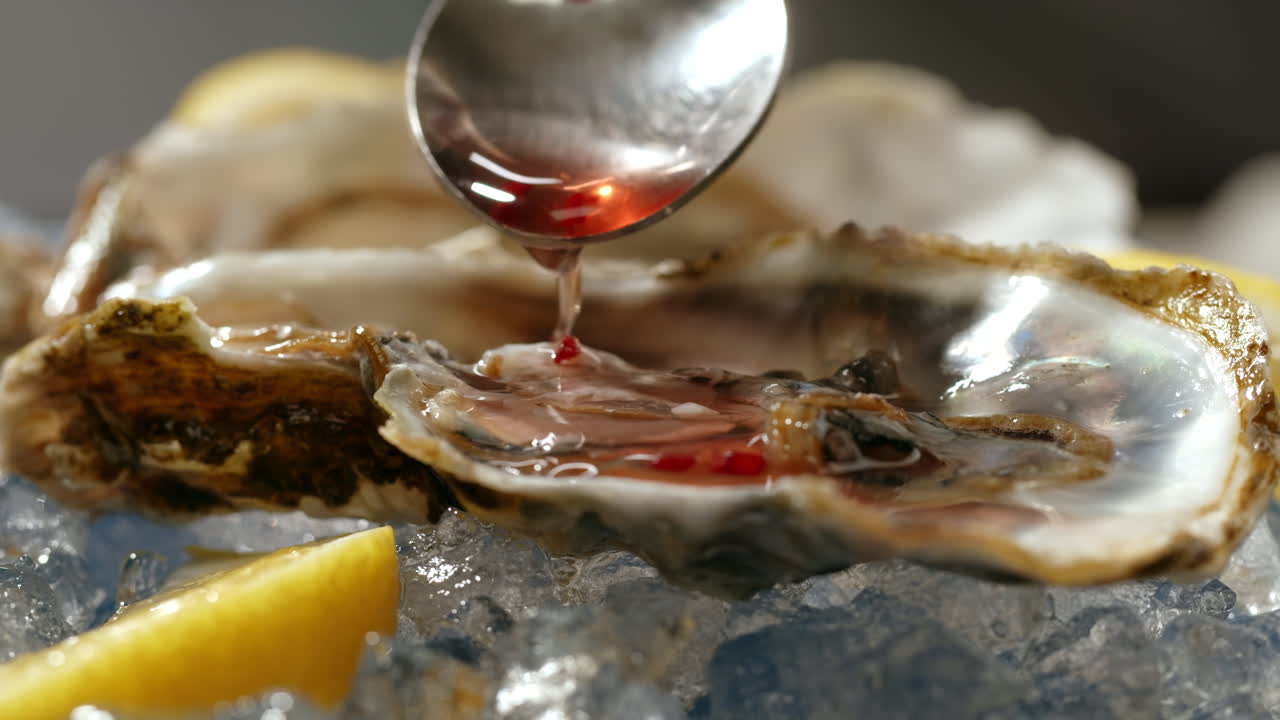 Fresh oysters on ice with red sauce