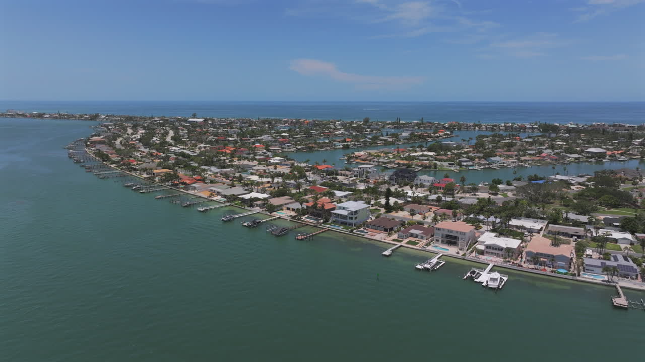 Drone shot of Florida tropical waterfront homes on the St Pete Beach intracoastal luxury neighborhood, capturing serene coastal living, marina lifestyle, and scenic paradise by the ocean
