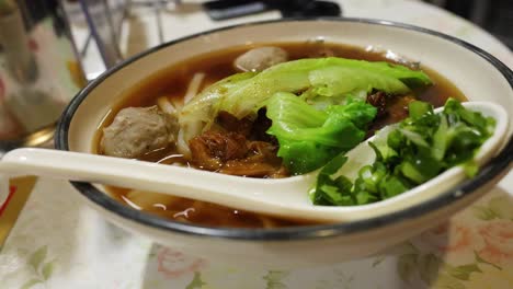 a bowl of beef noodle soup with vegetables