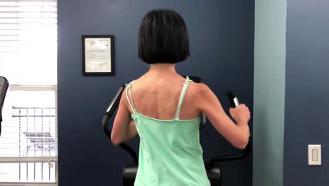 woman athlete on elliptical exercise machine in the gym - 4k slow motion athletic cardiovascular female workout