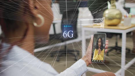 Animación-Del-Procesamiento-De-Datos-Sobre-Una-Mujer-Afroamericana-Que-Tiene-Una-Videollamada-En-Un-Teléfono-Inteligente-En-La-Oficina