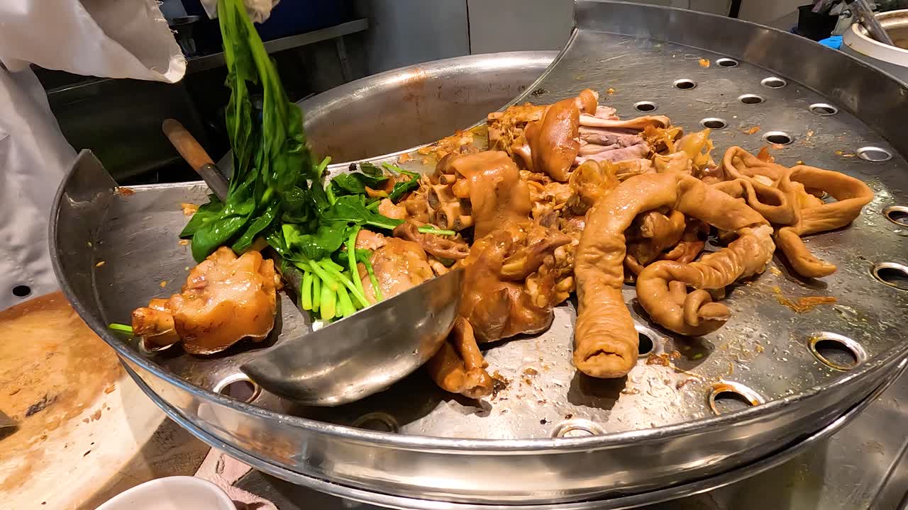 요리사는 전통적인 태국 김 돼지고기 다리를 준비합니다.