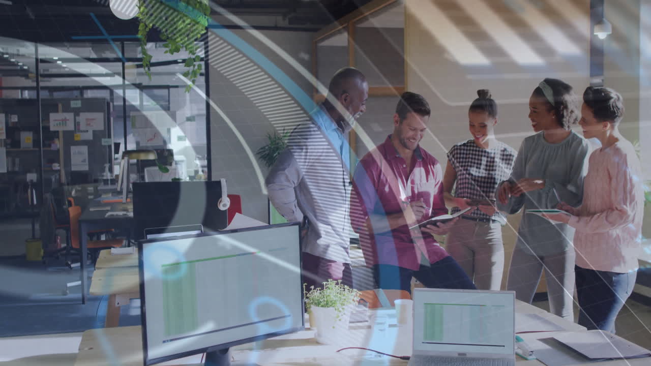 business team collaborating in bright office showing floating bar graph above laptop and phone