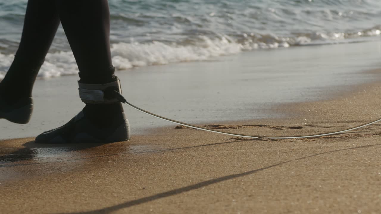 Surfer man walking to the beach at sunset preparing for surfing training and search for waves in Barcelona, spain, water, ocean exercise in sea with board, athletic male holiday or travel in vacation