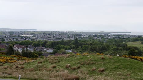 wide shot of the small, seaside village of stornoway and the houses and landscape surrounding it