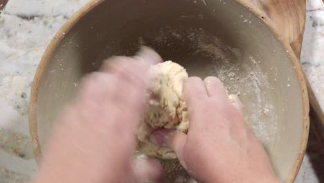 overhead view of hands kneading dough