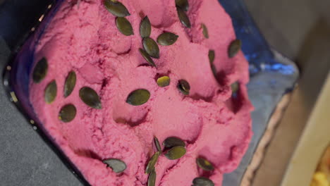 beet hummus with pumpkin seeds on bowl