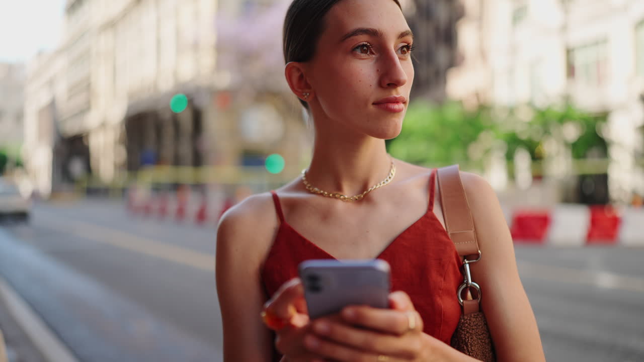 Giovane donna che usa il telefono in città