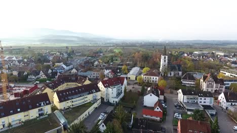 rising drone shot of the village denzlingen, germany on a cold autumn morning