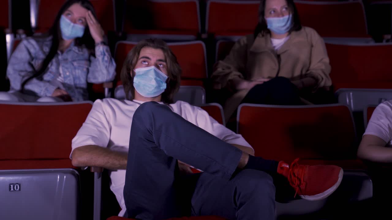 espectadores en un teatro con máscaras