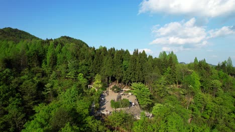 Drone-flying-towards-Helong-Park-amidst-lush-greenery-in-Tianzi-Mountain,-Wulingyuan