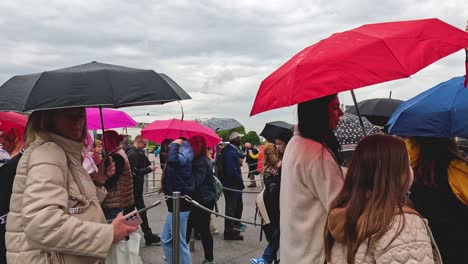 crowd with umbrellas near louvre on a rainy day