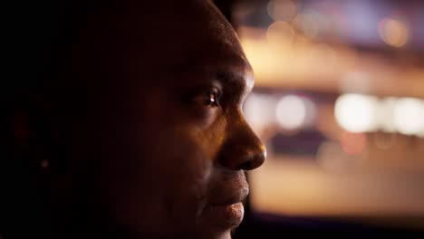 Close-up-a-confident-man-with-Black-skin-a-short-haircut-and-a-beard-rides-in-a-modern-car-interior-through-the-evening-city-during-his-business-trip