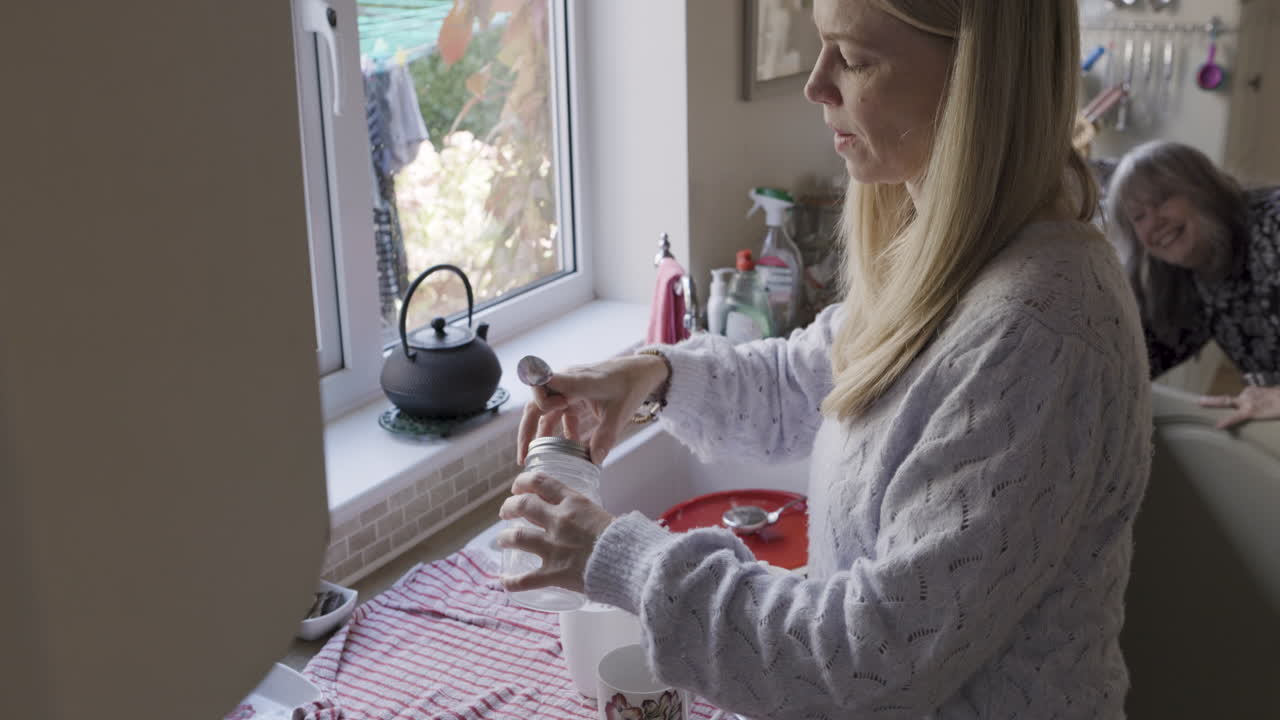Woman in kitchen washing jar