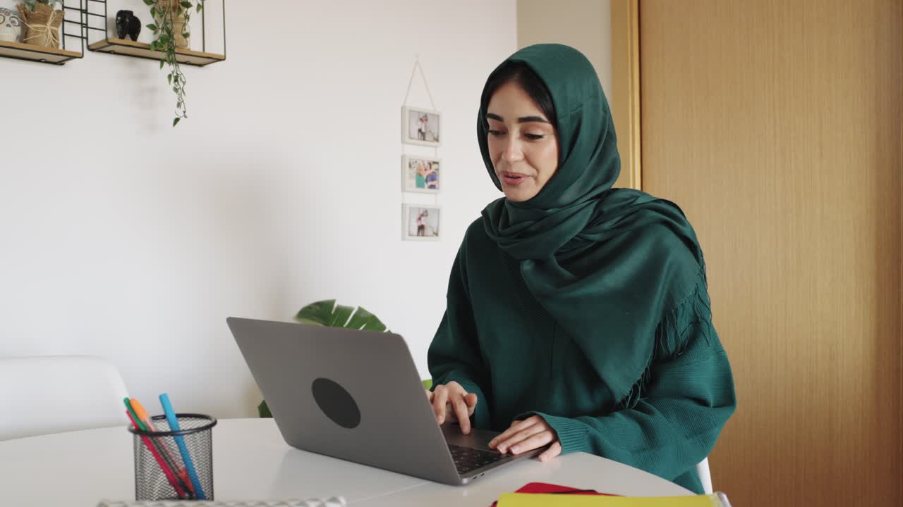 Woman in hijab working on laptop at home | Premium Stock Video Footage