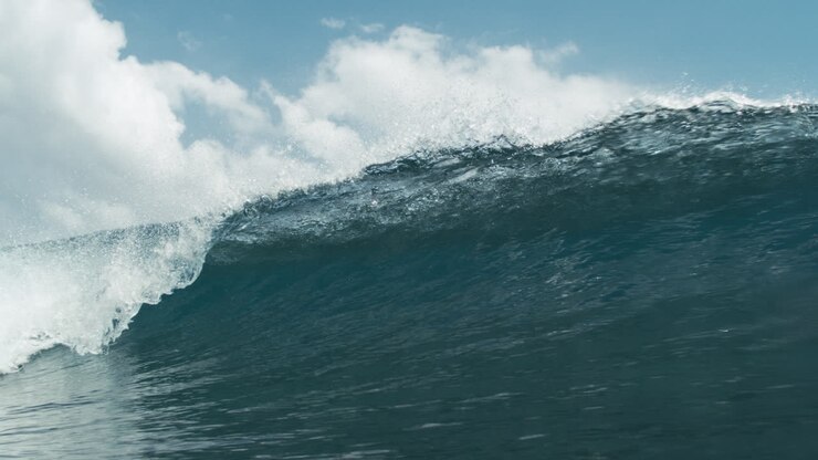 Blue wave begins to curl and crest in stunning slow motion closeup