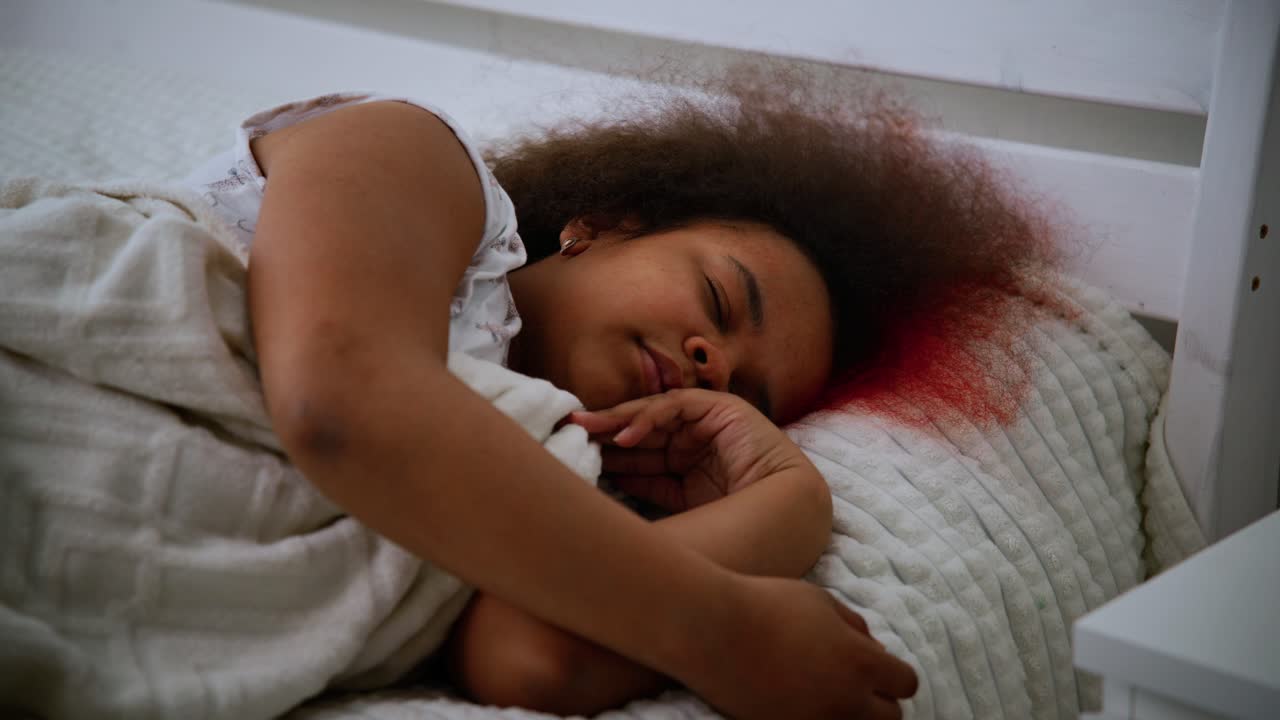 Distressed african american woman experiencing intense nightmare. Waking suddenly with blood stained pillow. Revealing deep psychological trauma from domestic violence and severe emotional suffering