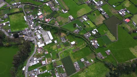 aerial over rural homesteads ecuador vibrant green arable farmland drone