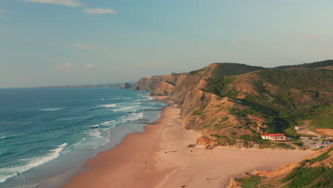 Aerial:-A-man-standing-on-a-viewpoint-watching-the-surfers-in-Portugal