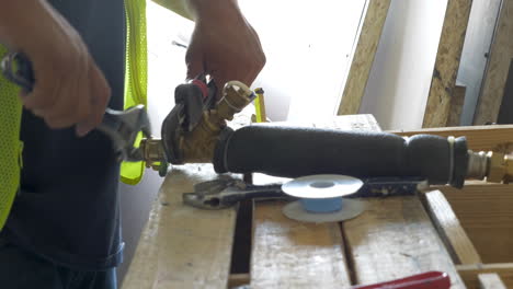 Construction worker repairing the fire sprinkler pipe in a commercial building during renovation