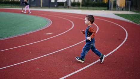 active toddler boy runs by the stadium approaching the ball. two year old kid learning sport and fit lifestyle.