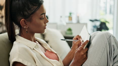 Woman,-relax-on-sofa-and-writing-in-notebook