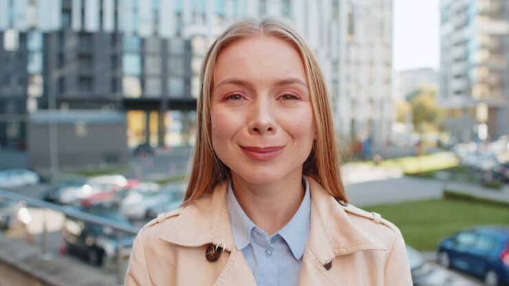 Ritratto in primo piano di una donna felice e matura con il viso sorridente e amichevole che guarda la telecamera in una strada della città