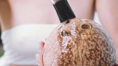 Close-up-of-female-hands-covering-a-sanded-coconut-shell-with-oil