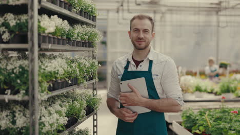 male gardener with tablet in a plant nursery