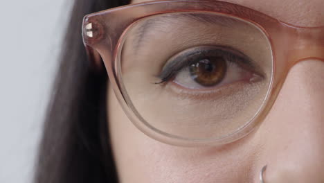 cerrar el ojo de una mujer joven mirando a la cámara parpadeando con gafas elegantes