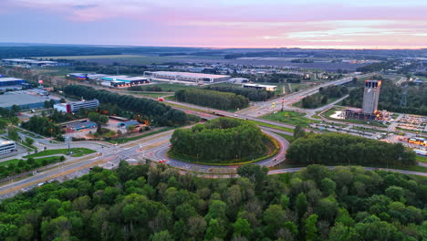 Highways, bridges and roundabouts in the countryside. Outskirts of the city at sunset. Aerial view.