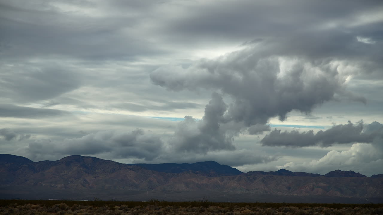 nubes dramáticas sobre el desierto de mojave con el fondo de la montaña, timelapse