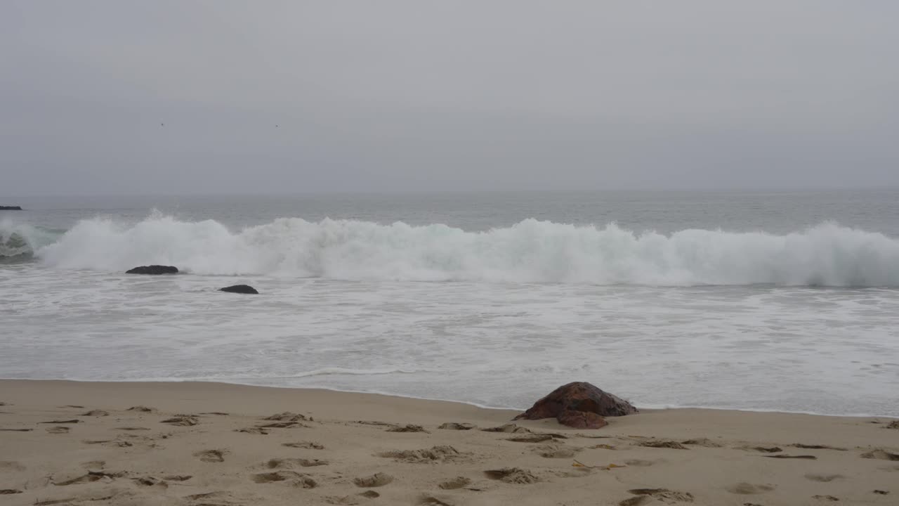 아름다운 모양의 에메랄드색 파도가 말리부 해변의 모래 해변에 굴러서 바다의 순수한 힘과 아름다움을 포착하는 놀라운 클립.